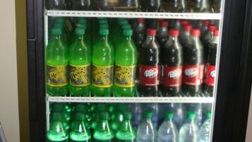 A beverage vending machine stocked with various drinks including sodas, energy drinks, and bottled water.