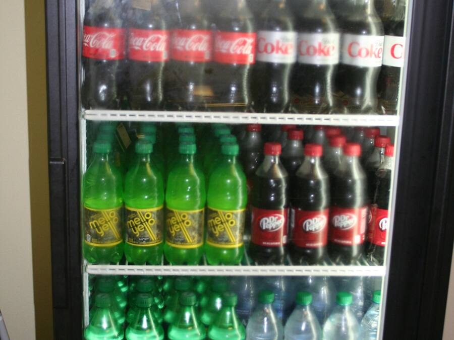 A beverage vending machine stocked with various drinks including sodas, energy drinks, and bottled water.