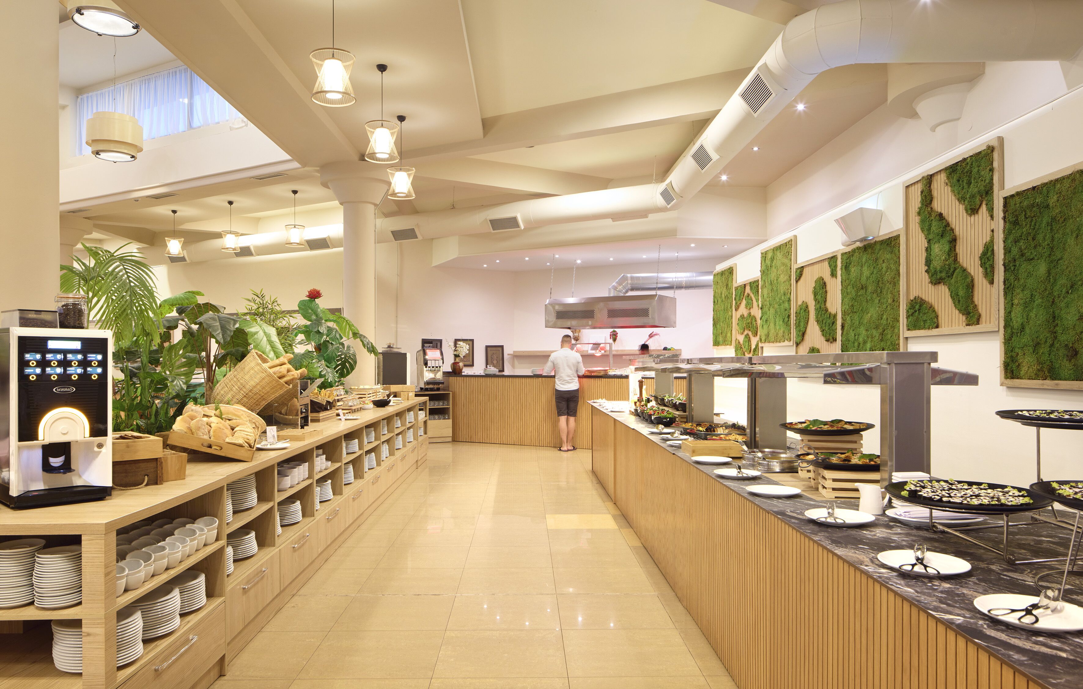A spacious buffet area with a long counter, various food stations, and a coffee machine.