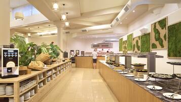 A spacious buffet area with a long counter, various food stations, and a coffee machine.