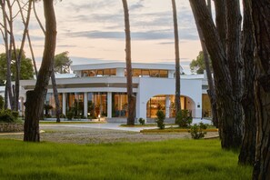 A modern building with a flat roof, large windows, and a well-maintained lawn. - Sol Tropikal Durres (Durrës)