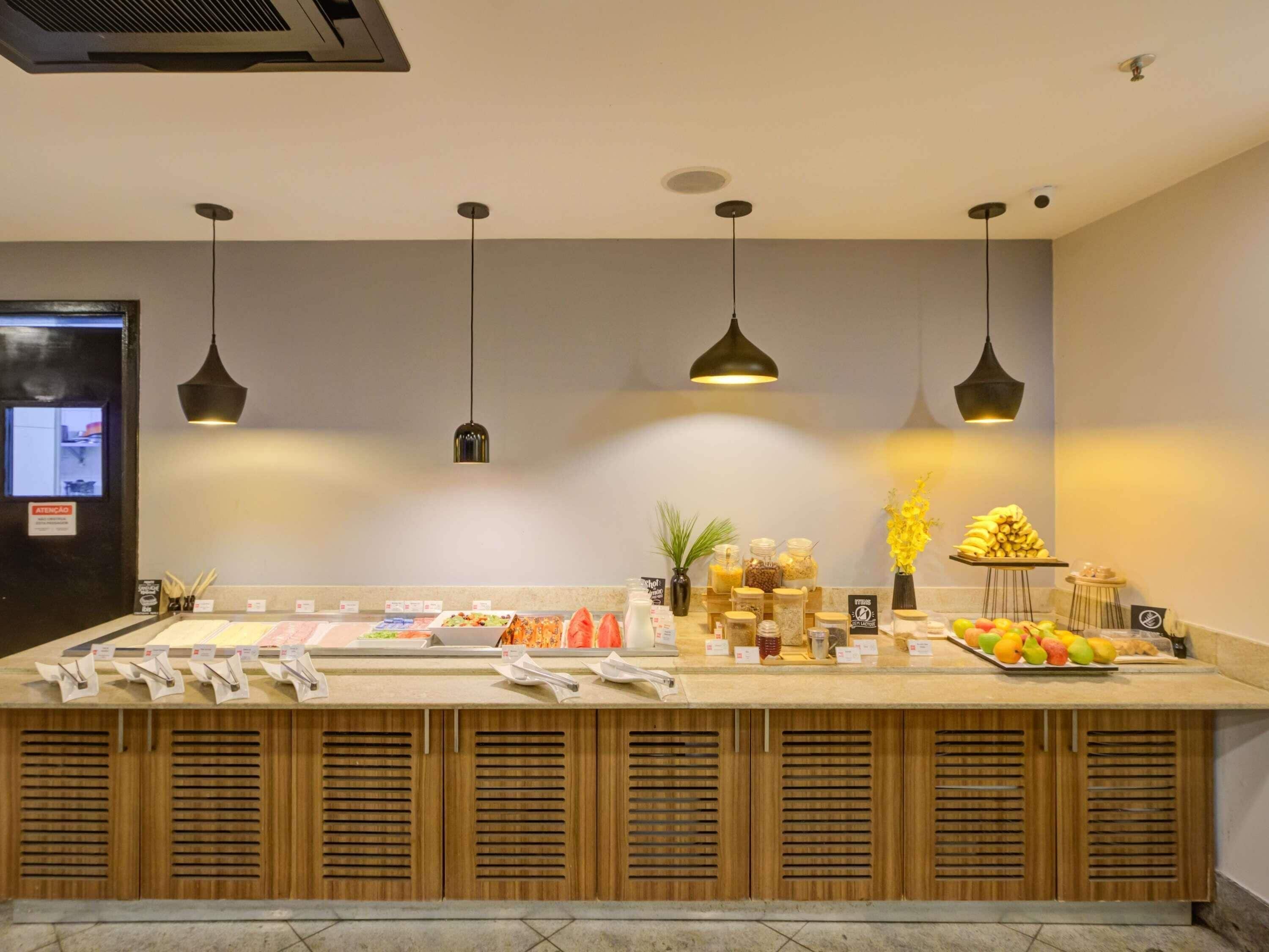 A buffet counter with various food items and a sign indicating a 24-hour service.