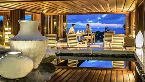 An outdoor dining area with a view of the sea, wooden flooring, and large vases. - Pullman Phuket Arcadia Naithon Beach (Sa Khu)
