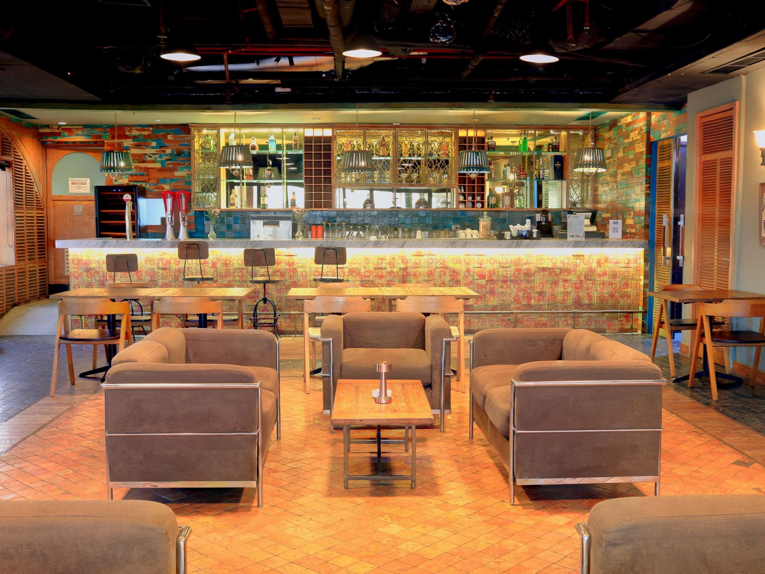 A bar area with a counter, seating, and a patterned wall.