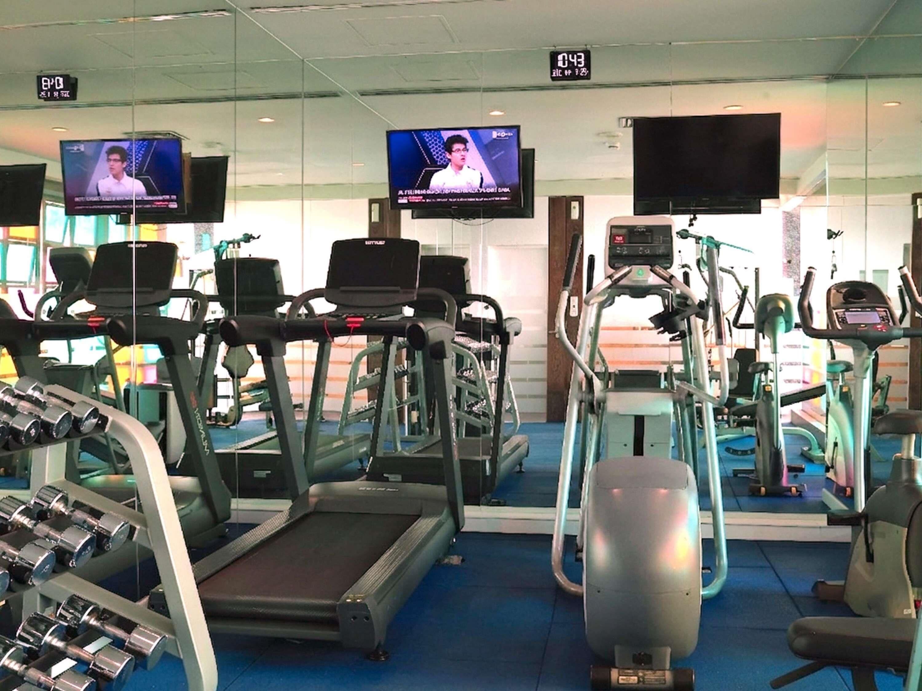 A gym with treadmills, elliptical machines, and weight machines.