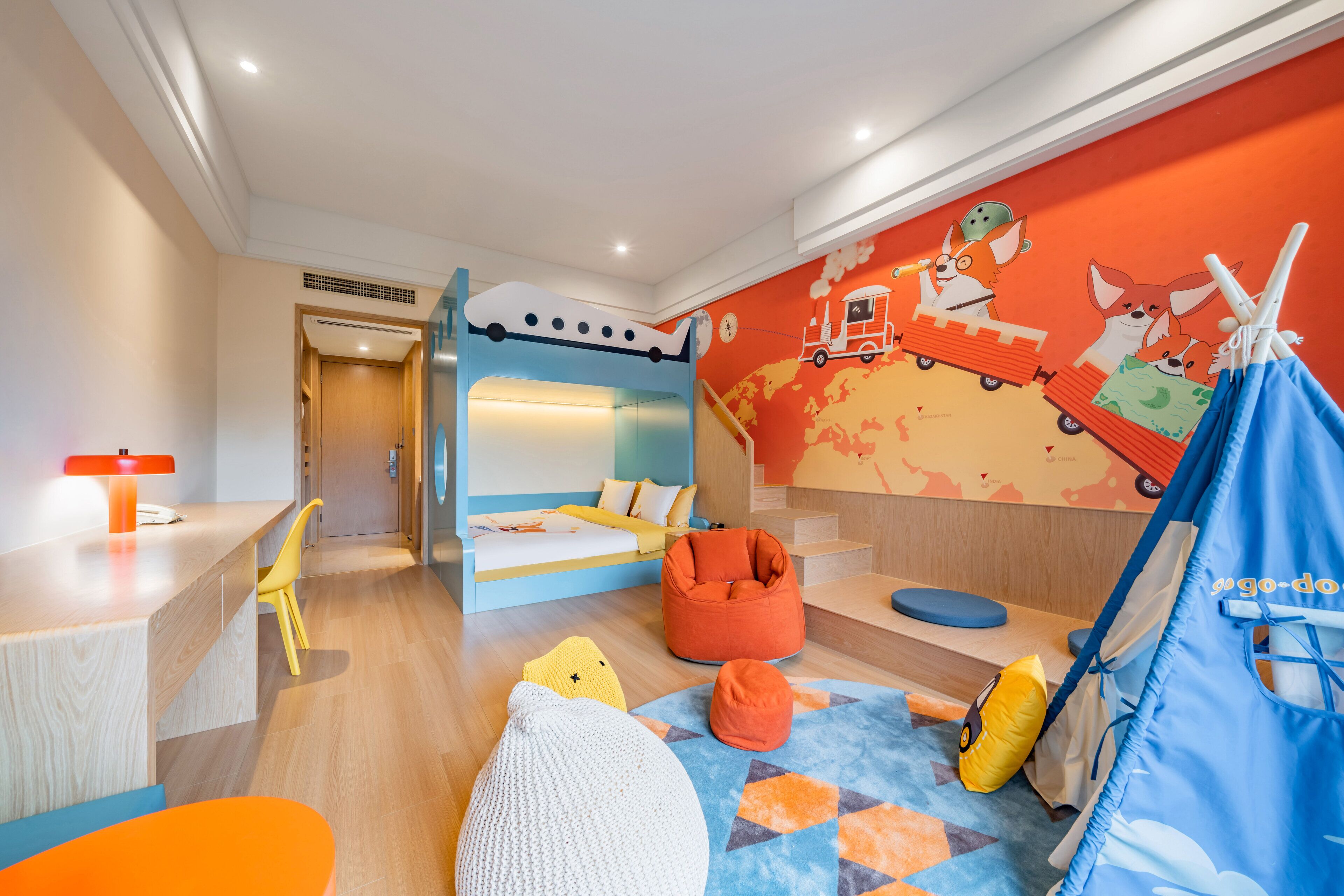 Ein Kinderzimmer mit einem Etagenbett, einem Schreibtisch und einem Spielbereich.