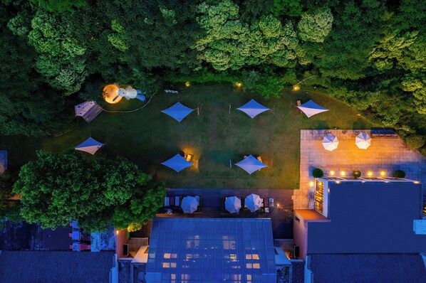An aerial view of a rooftop with multiple tents and a glass-roofed building.