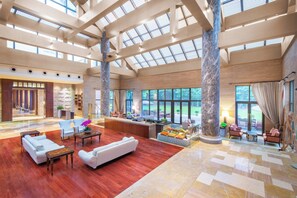 A spacious lobby with high ceilings, large windows, and a central seating area with sofas and a coffee table. - Holiday Inn Resort Chaohu Hot Spring by IHG (Hefei)