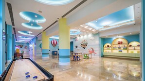 A spacious lobby with a shuffleboard table, a children's play area, and a wall decorated with nautical and travel-themed murals. - Holiday Inn Resort Chaohu Hot Spring by IHG (Hefei)