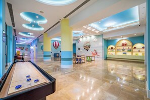 A spacious lobby with a shuffleboard table, a children's play area, and a wall decorated with nautical and travel-themed murals. - Holiday Inn Resort Chaohu Hot Spring by IHG (Hefei)
