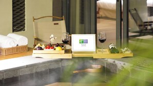 A spa area with a hot tub, wooden trays with fruits, wine glasses, and a framed sign. - Holiday Inn Resort Chaohu Hot Spring by IHG (Hefei)