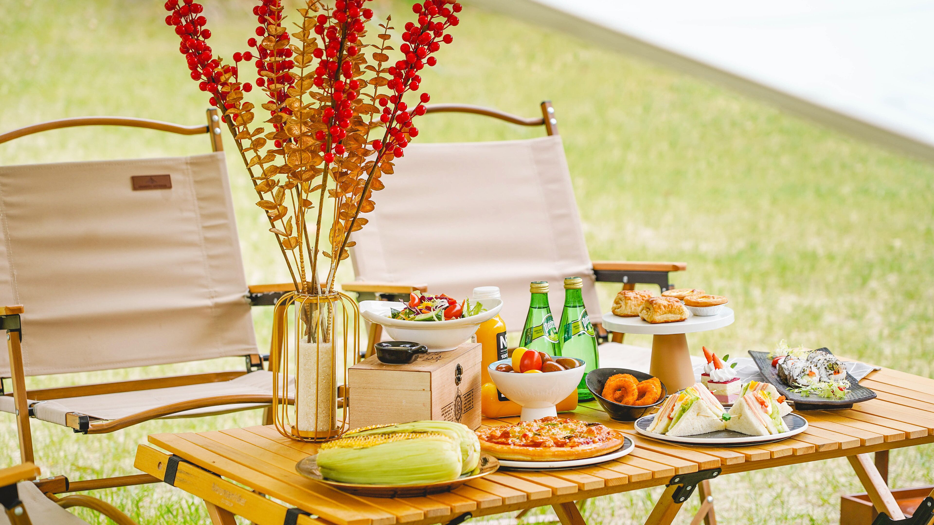 Un montaje para picnic con una mesa, sillas y diferentes alimentos.