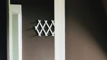 A room with a dark wall, a white door, and a wooden floor.