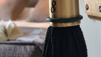A brass door handle with a black tassel and the number 8.