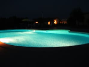 A swimming pool at night with illuminated edges.