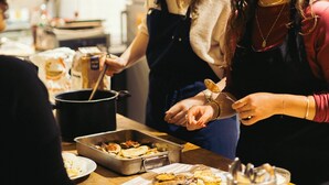 A group of people in a kitchen preparing food. - QUO Milano - Hostel (Milan)