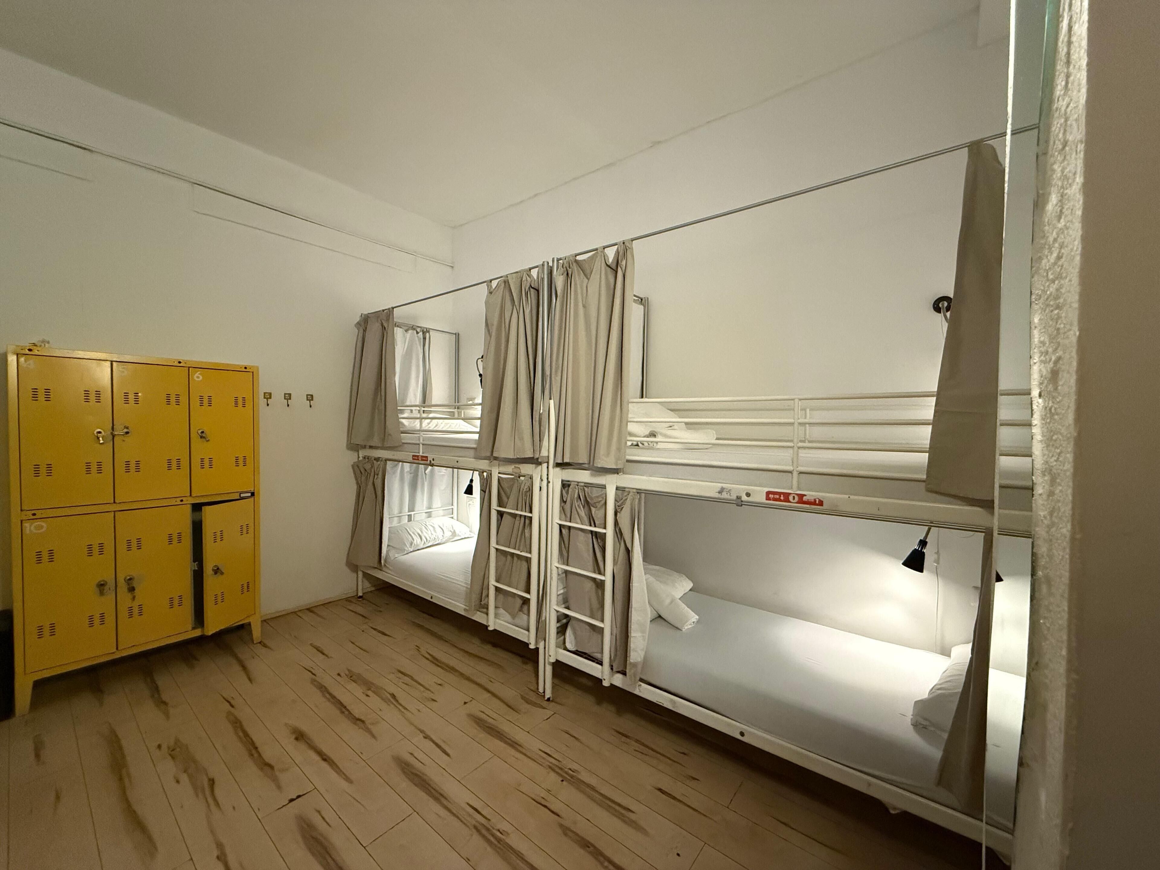 Una camera del dormitorio con letti a castello, pavimento in legno e una serie di armadietti gialli.