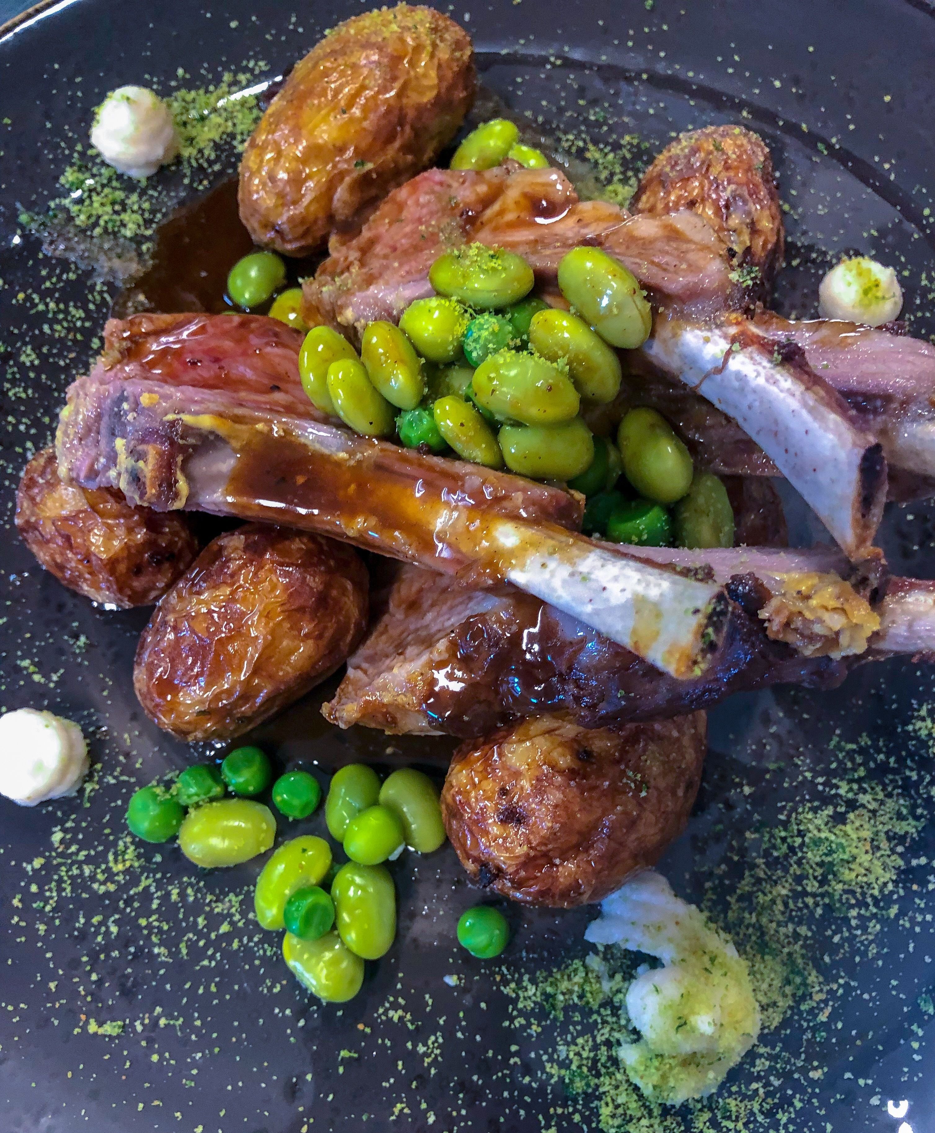 Ein Gericht mit gebratenem Fleisch, Kartoffeln und Erbsen.