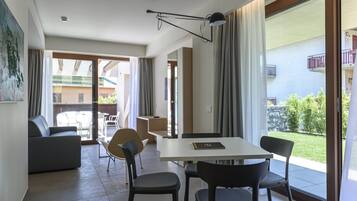 Una sala de estar moderna con comedor, puertas corredizas de vidrio que dan a un balcón y vistas de los edificios circundantes.