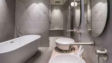 A modern bathroom with a freestanding bathtub, a large mirror, and a wooden vanity with two bowls.