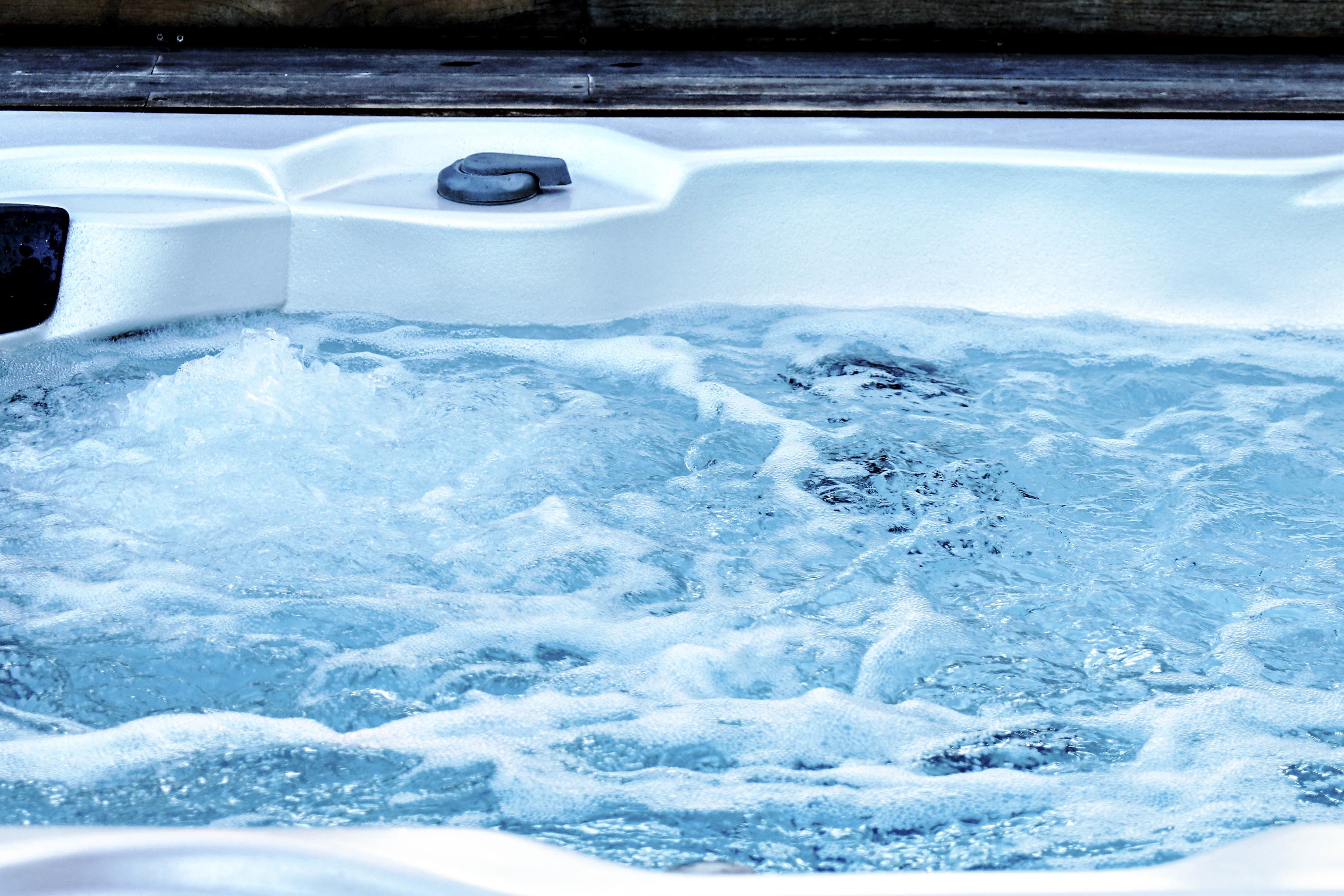 A hot tub with visible water jets and a control panel.