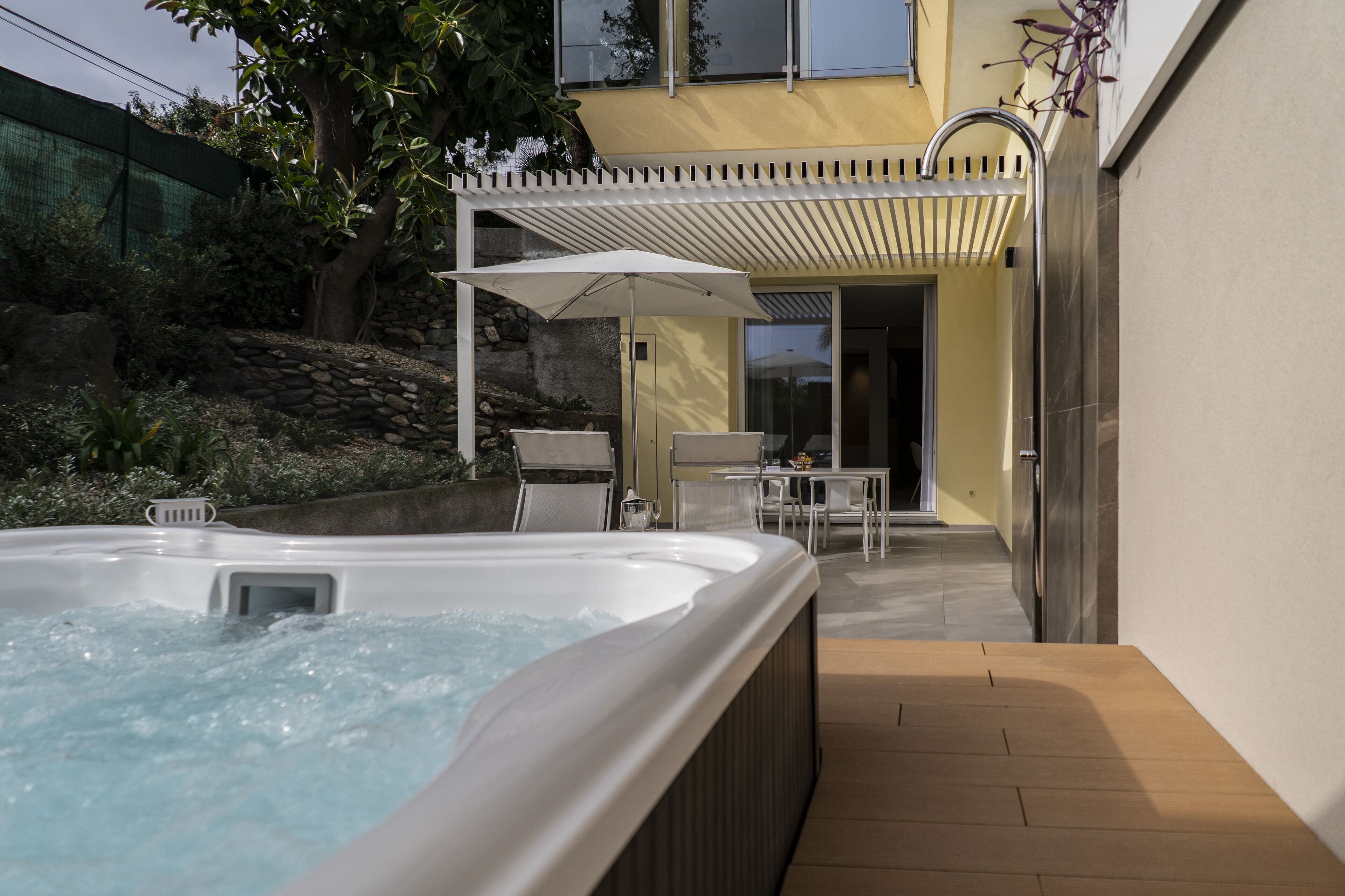 Un bain à remous doté d’une pergola et d’un espace salon extérieur.