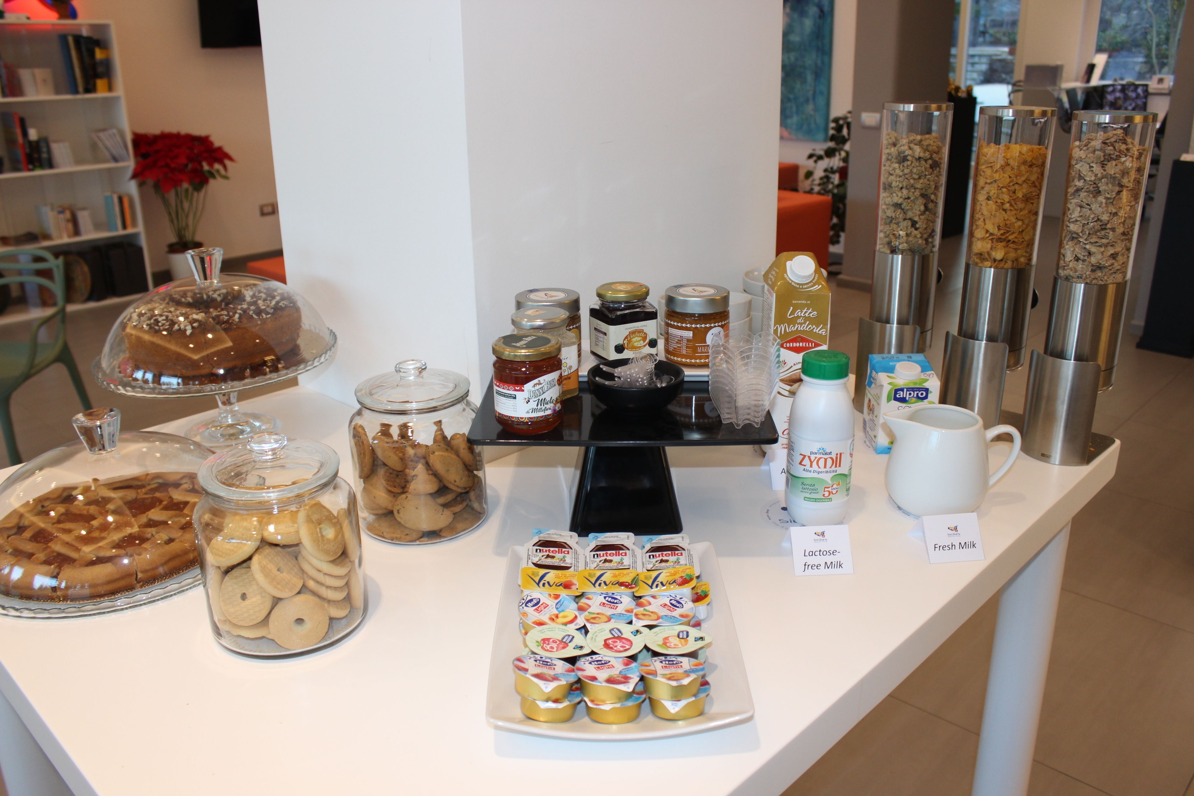 Una mesa de buffet con diversos alimentos, entre ellos pasteles, galletas y productos lácteos.