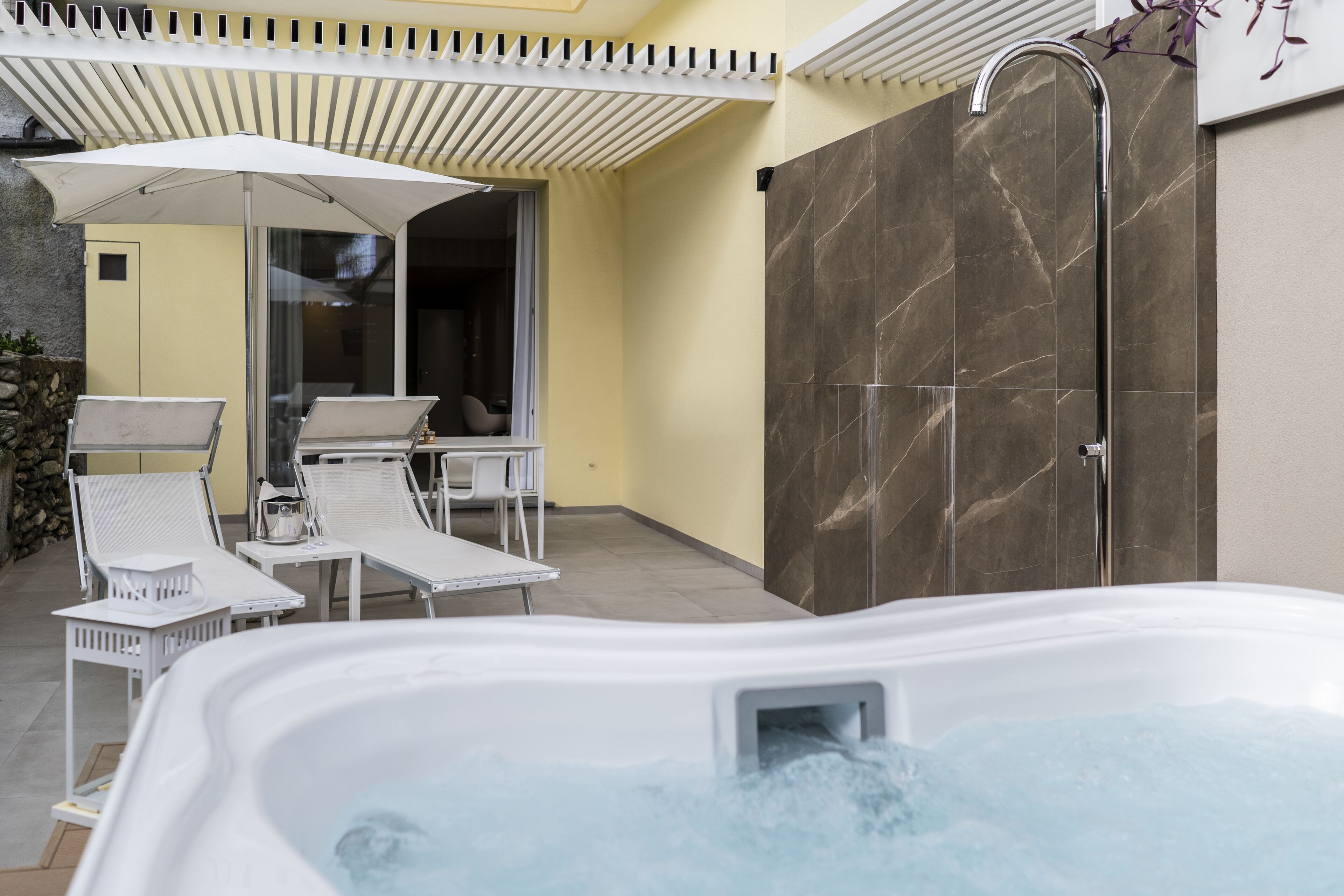 Un área de spa con una bañera de hidromasaje, sillas de descanso y un box de ducha.