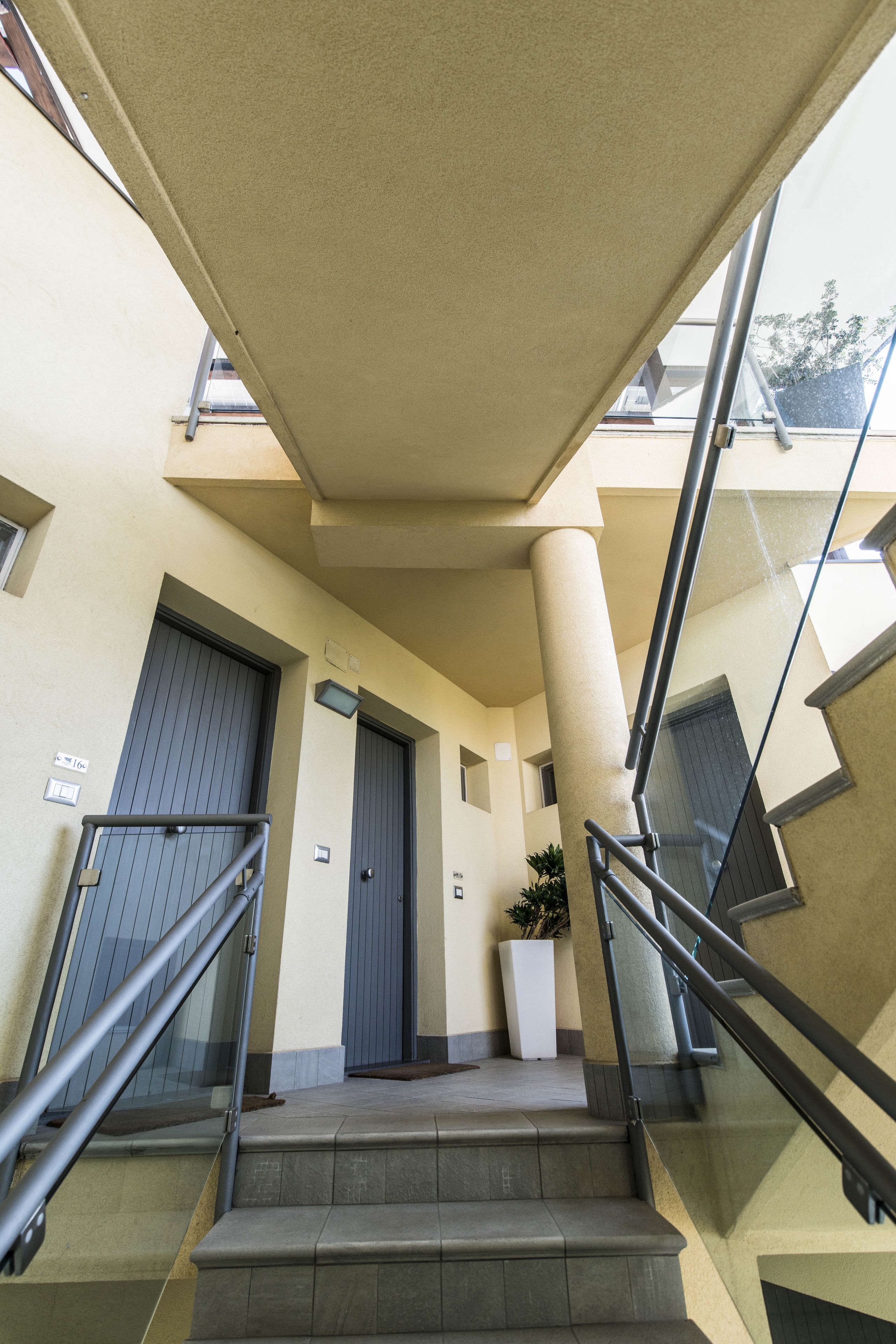A modern building with a staircase, a door, and a potted plant.