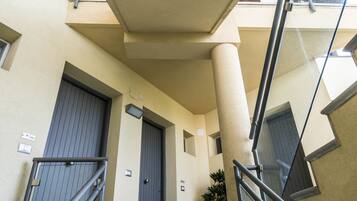 A modern building with a staircase, a door, and a potted plant.