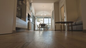 Un interior moderno con piso de madera, un comedor con sillas y una mesa, y un sofá.