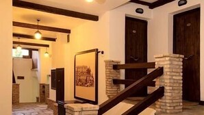 A staircase with stone steps and wooden railings, leading to a door with a stone pillar. - Taxiarches Hotel (Zagori)