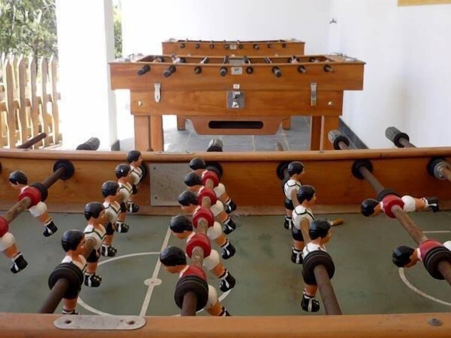 A foosball table with multiple players in red and white uniforms.