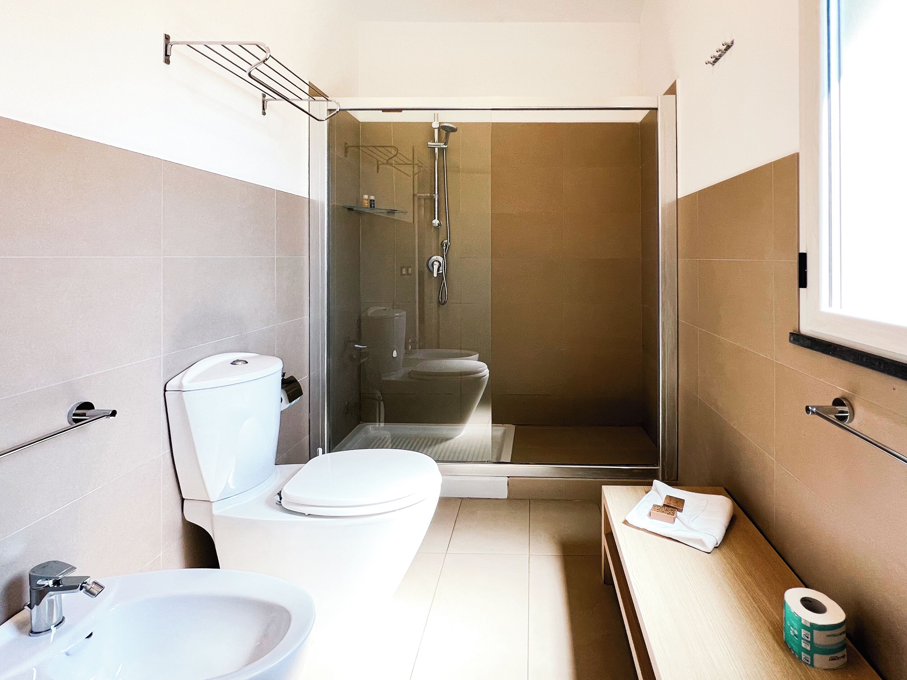 A compact bathroom with a toilet, sink, and shower.