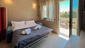 A bedroom with a bed, a window with curtains, and a view of the outside.