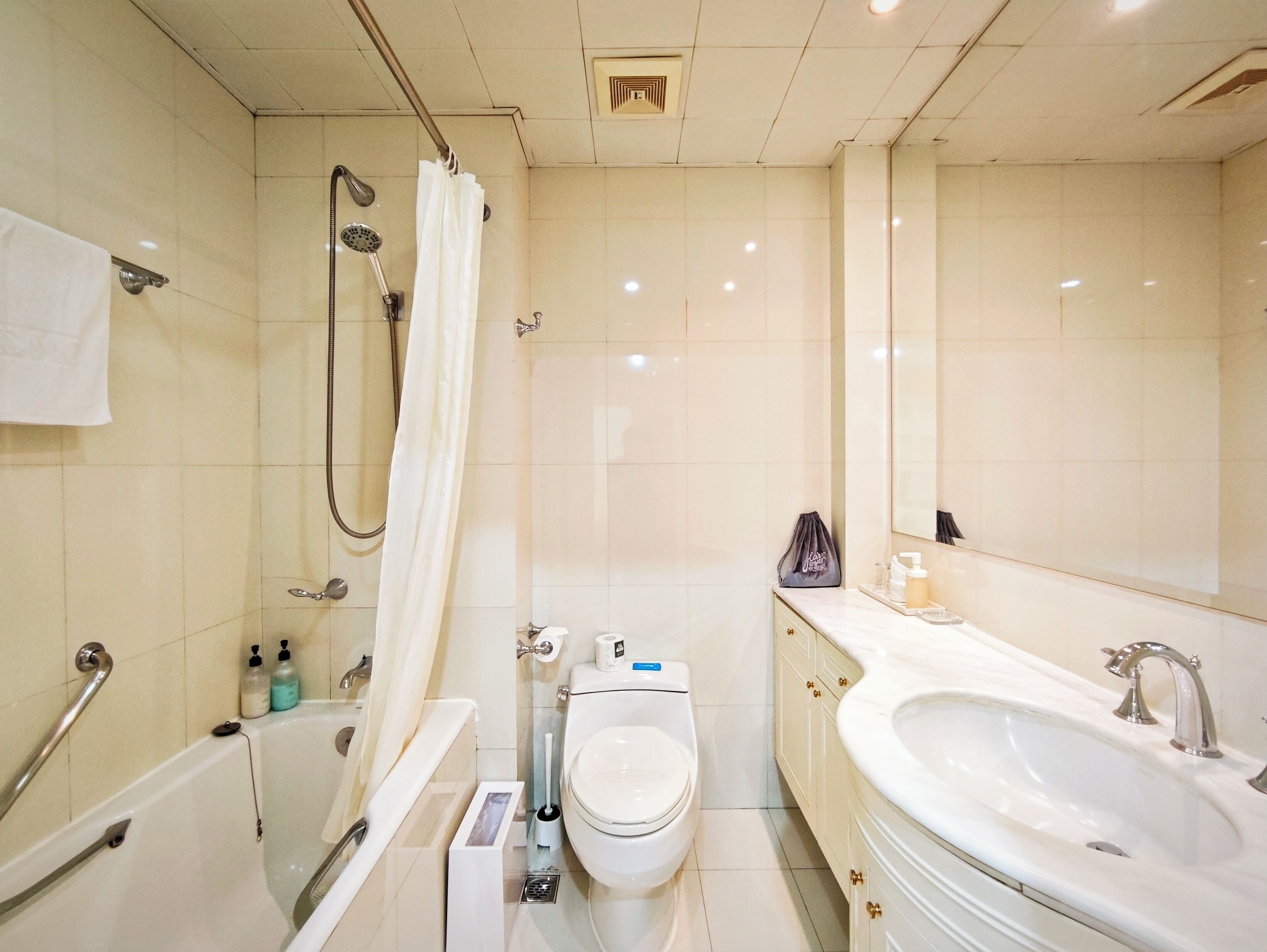 A modern bathroom with a bathtub, shower, toilet, and sink.