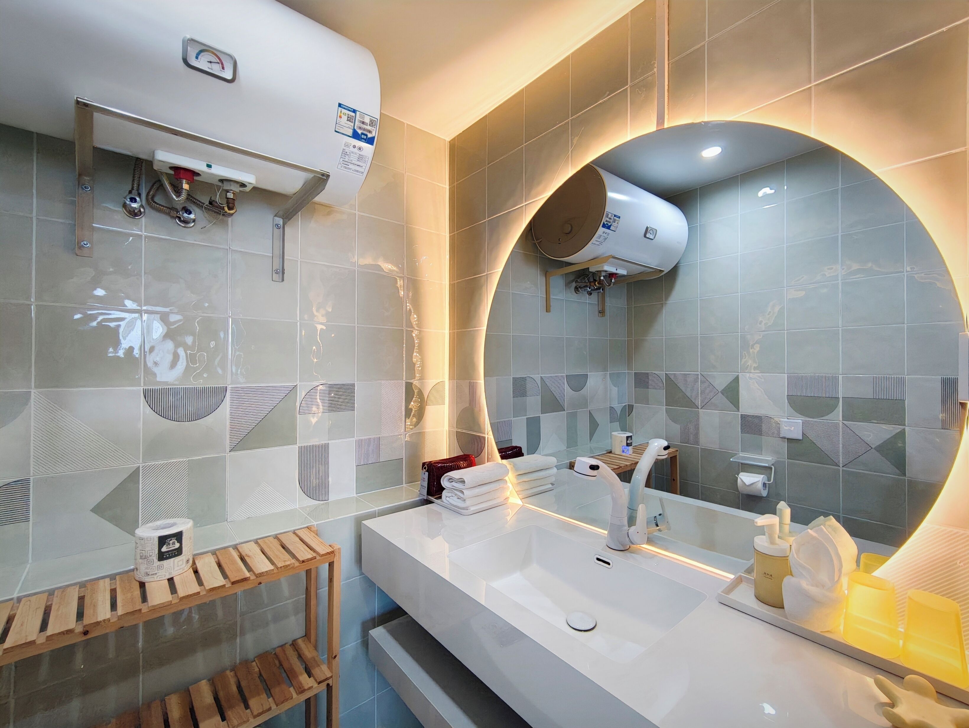 A modern bathroom with a large mirror, a white sink, and a towel rack.