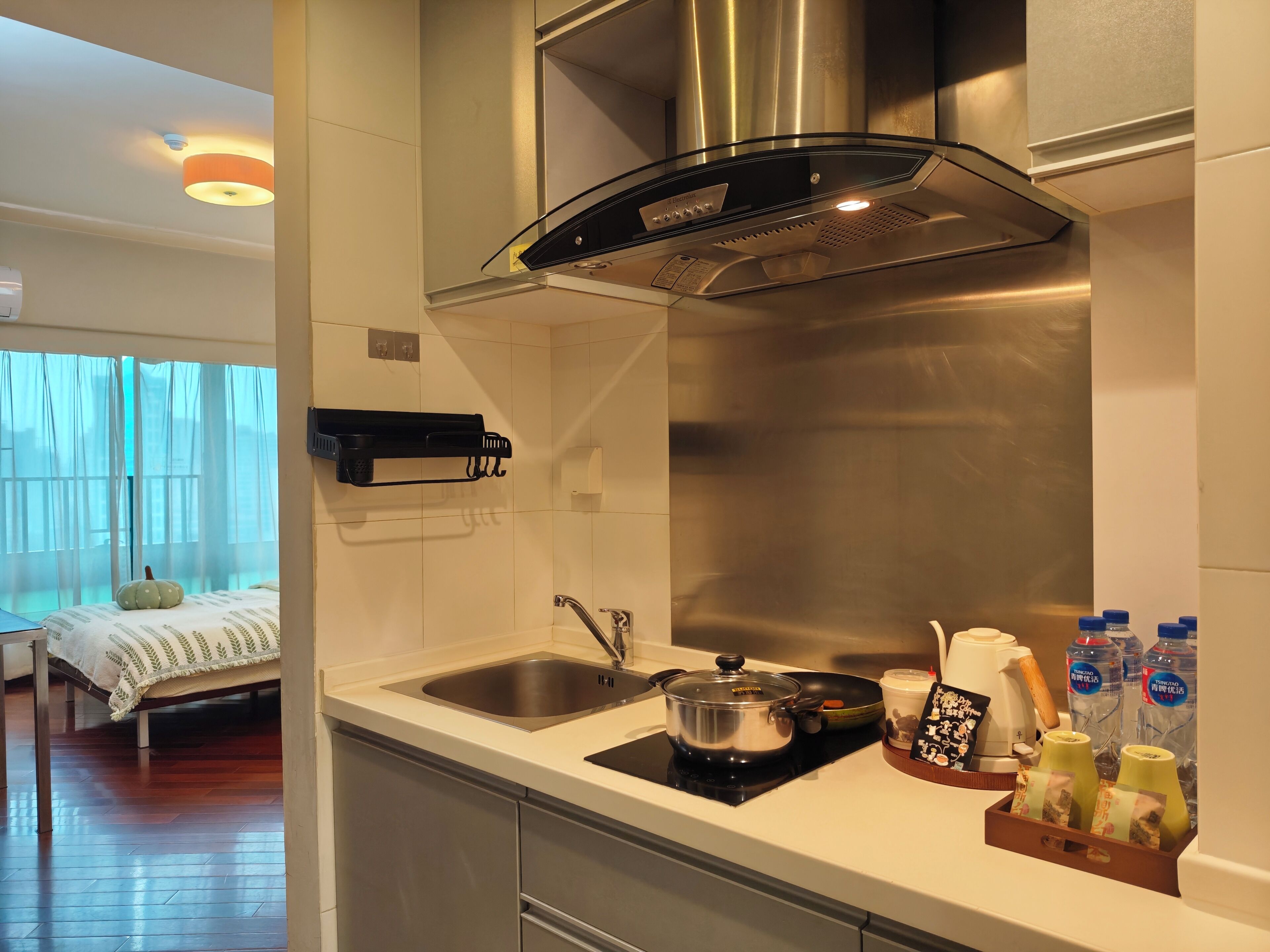A modern kitchen with a stainless steel range hood, a sink, and a stove.