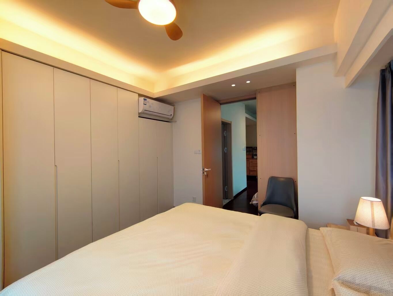 Une chambre d’hôtel équipée d’un lit, d’un bureau, d’une chaise, d’un climatiseur et d’une lampe.