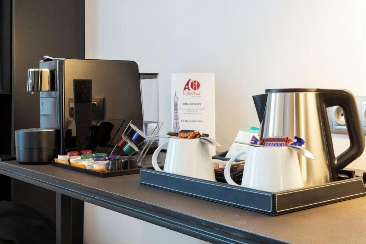 Een hotel receptiebalie met een koffieapparaat, een waterkoker en een bord.