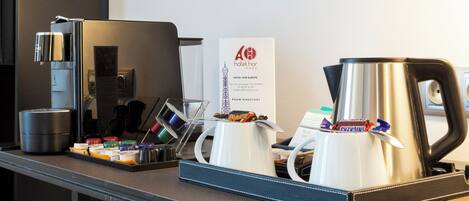 A hotel reception area with a coffee station, a room directory sign, and a minibar.