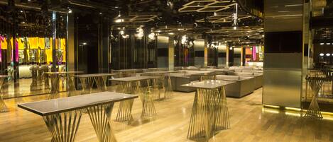 A modern interior with tables and sofas arranged in a spacious area.
