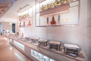 Un espace buffet comprenant plusieurs stands de nourriture et un long comptoir.