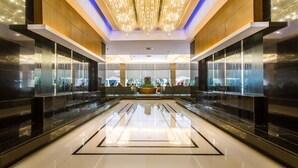 A spacious lobby with a reflective floor, modern chandeliers, and a central seating area. - Holiday Inn Express Manila Newport City by IHG (Pasay)