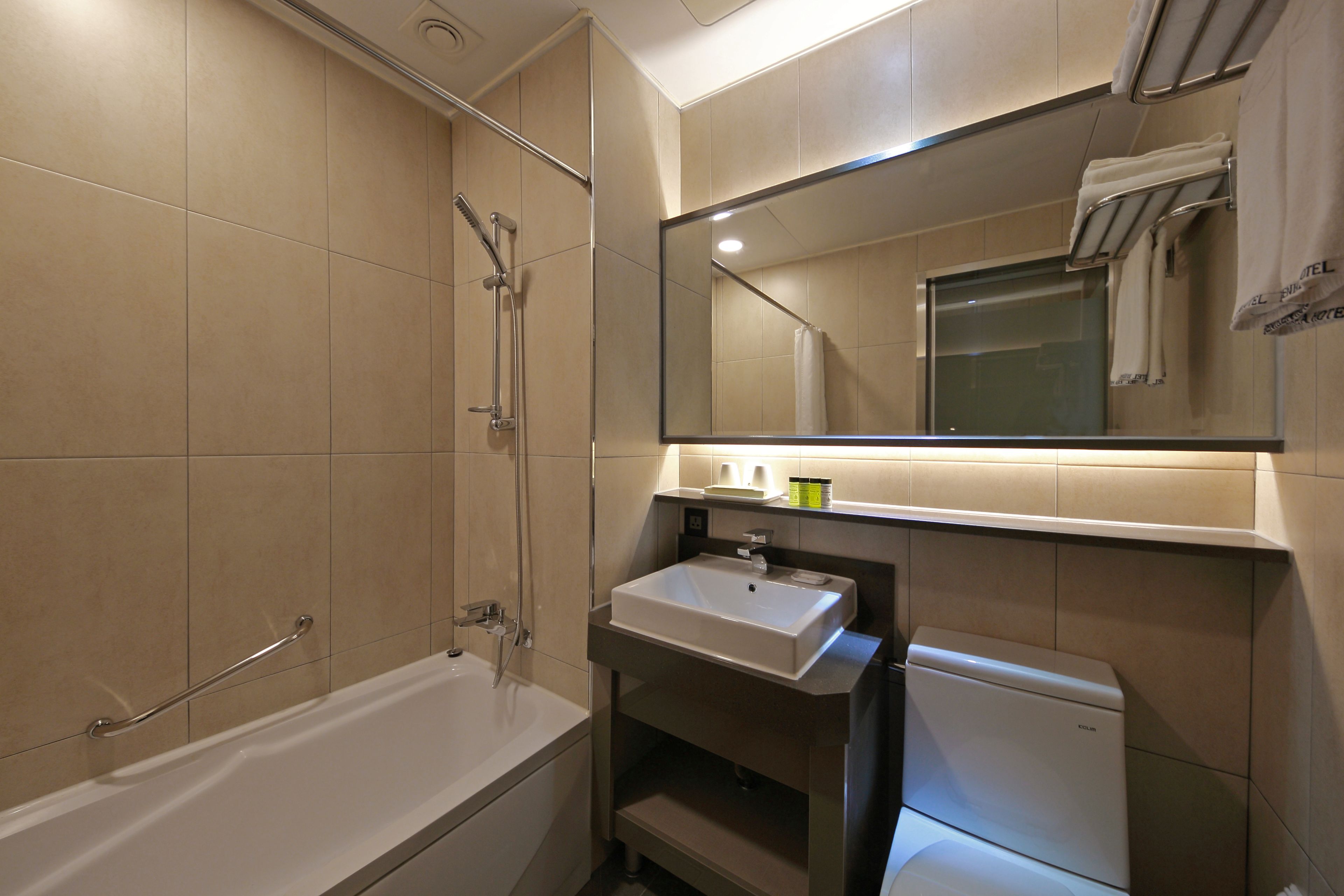 A modern bathroom with a bathtub, a sink, and a toilet.