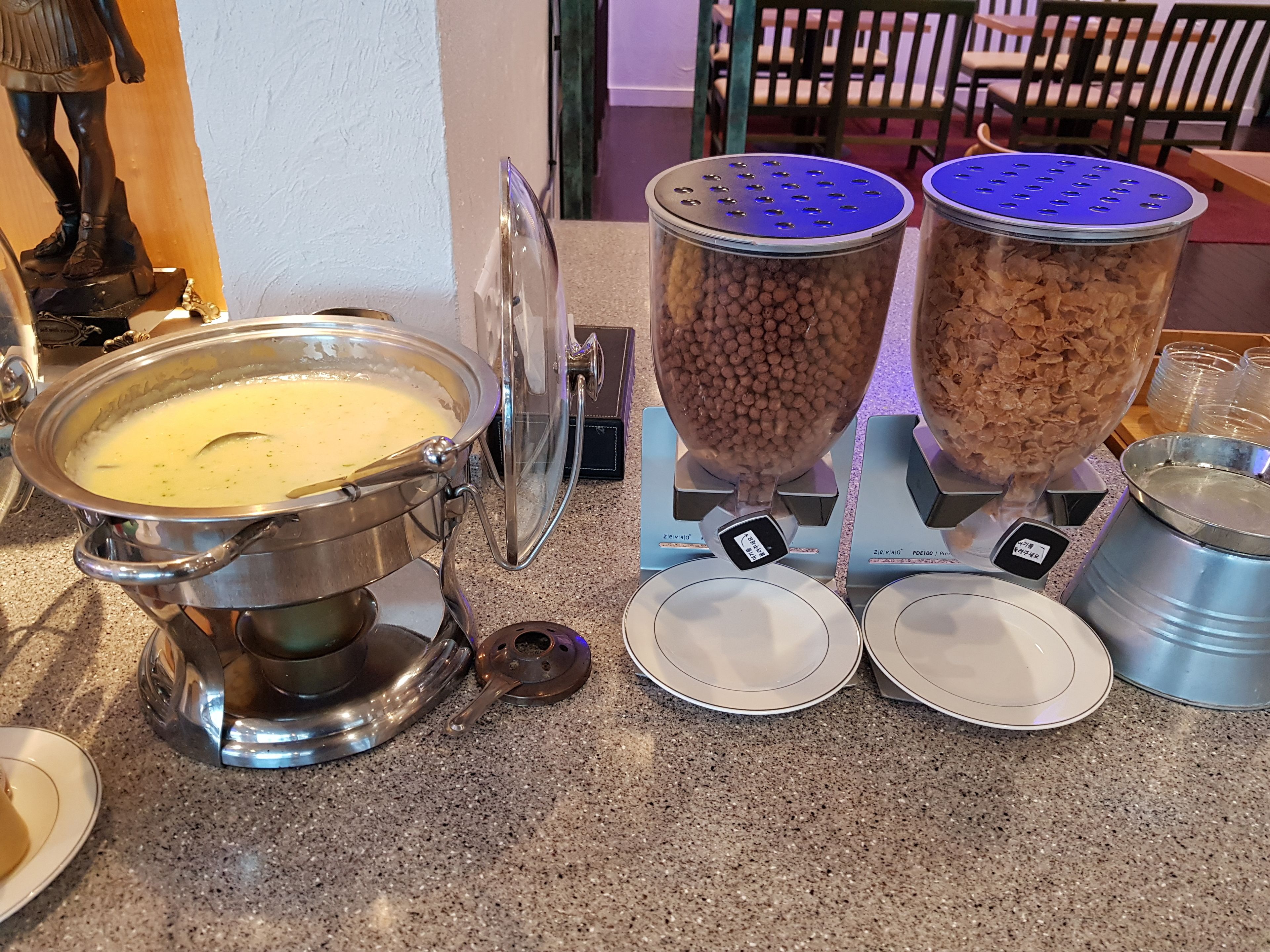 A buffet setup with a soup pot, two containers of beans, and a weighing scale.
