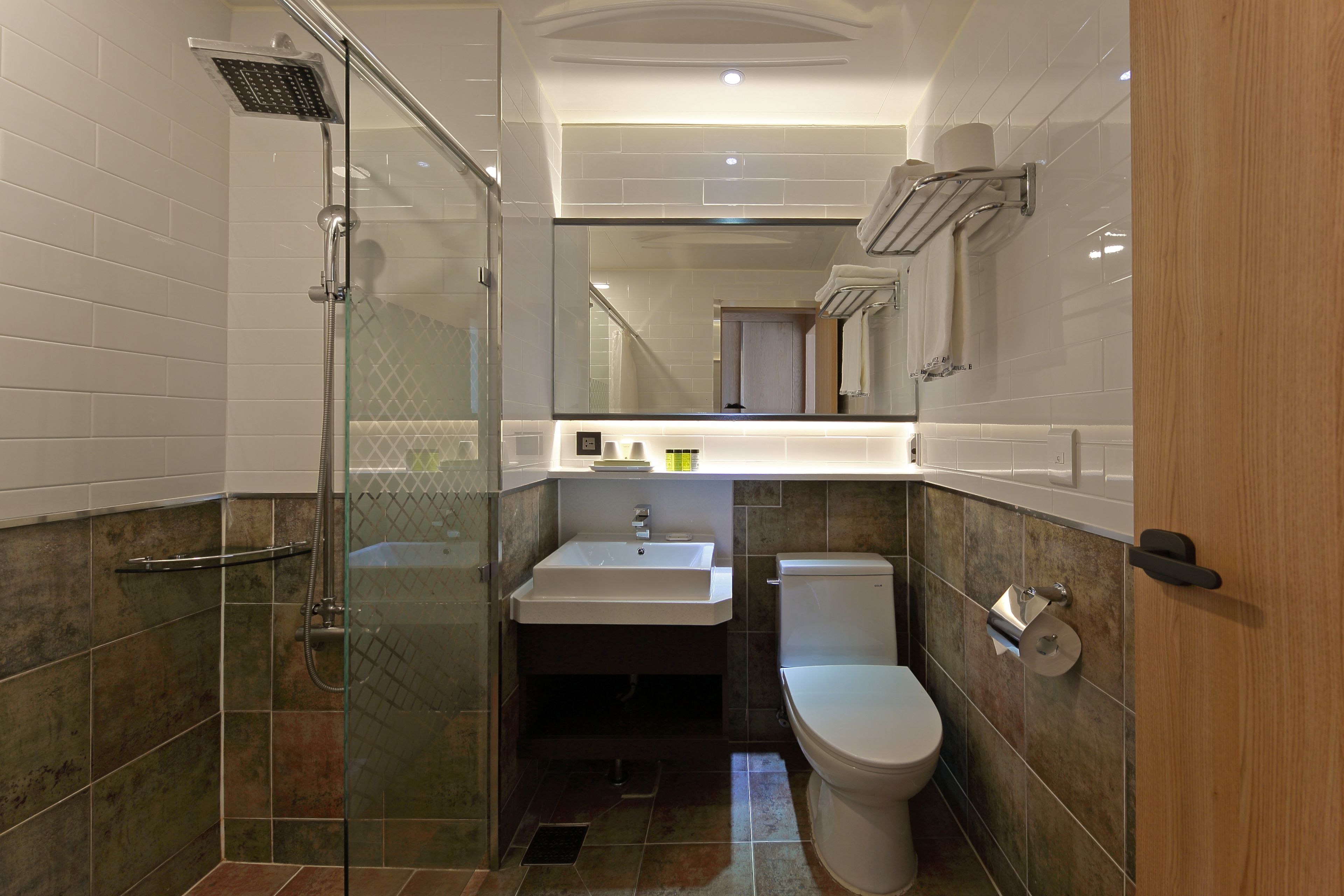 A modern bathroom with a glass-enclosed shower, a white sink, and a toilet.