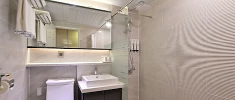 A modern bathroom with a toilet, sink, and shower.