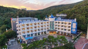 Un hôtel à plusieurs étages doté d’une cour intérieure, de balcons et d’une enseigne indiquant qu’il s’agit de l’hôtel Swiss Rosen.