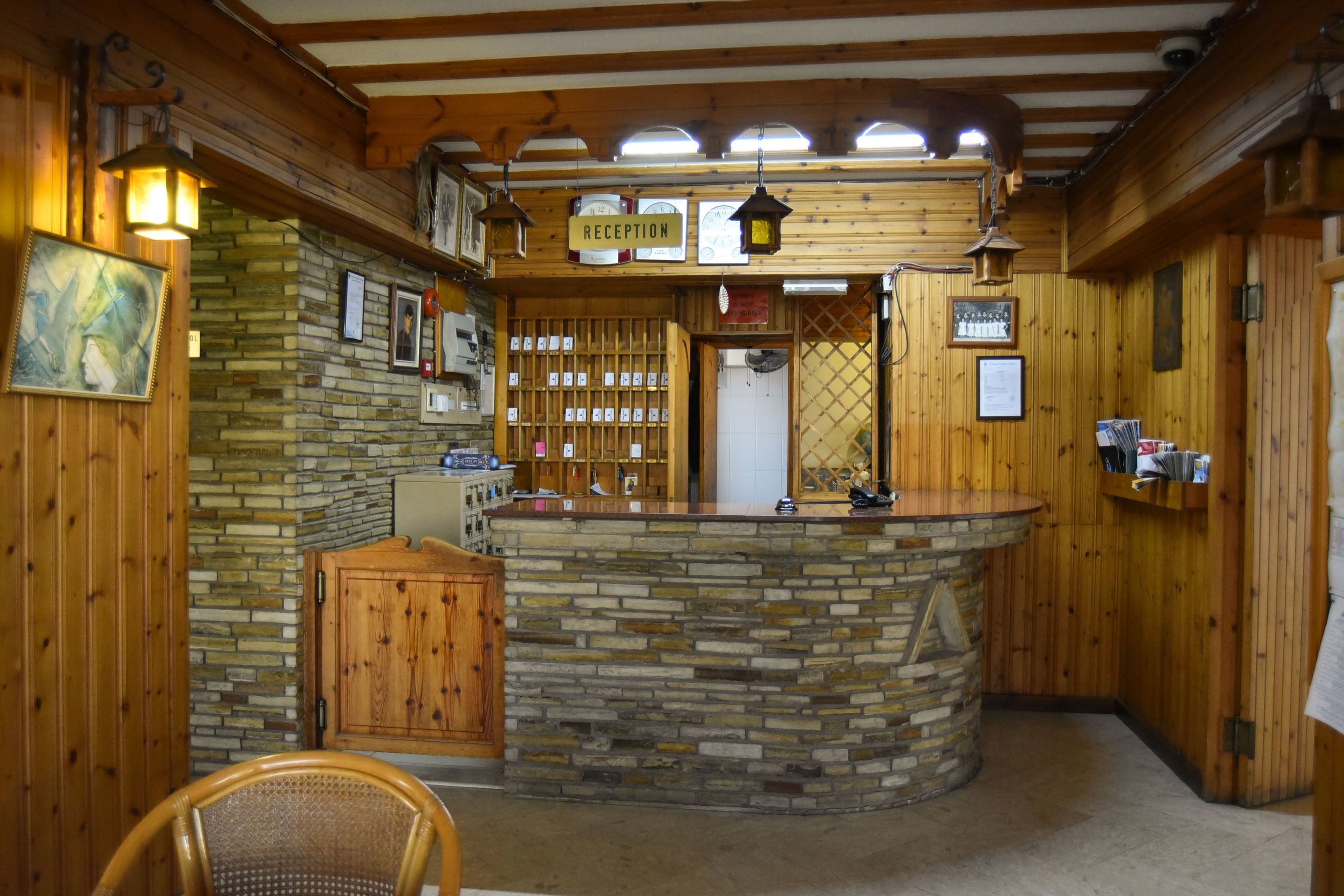 Un espace d’accueil doté d’un comptoir en pierre, de murs en bois et d’un bureau de réception.